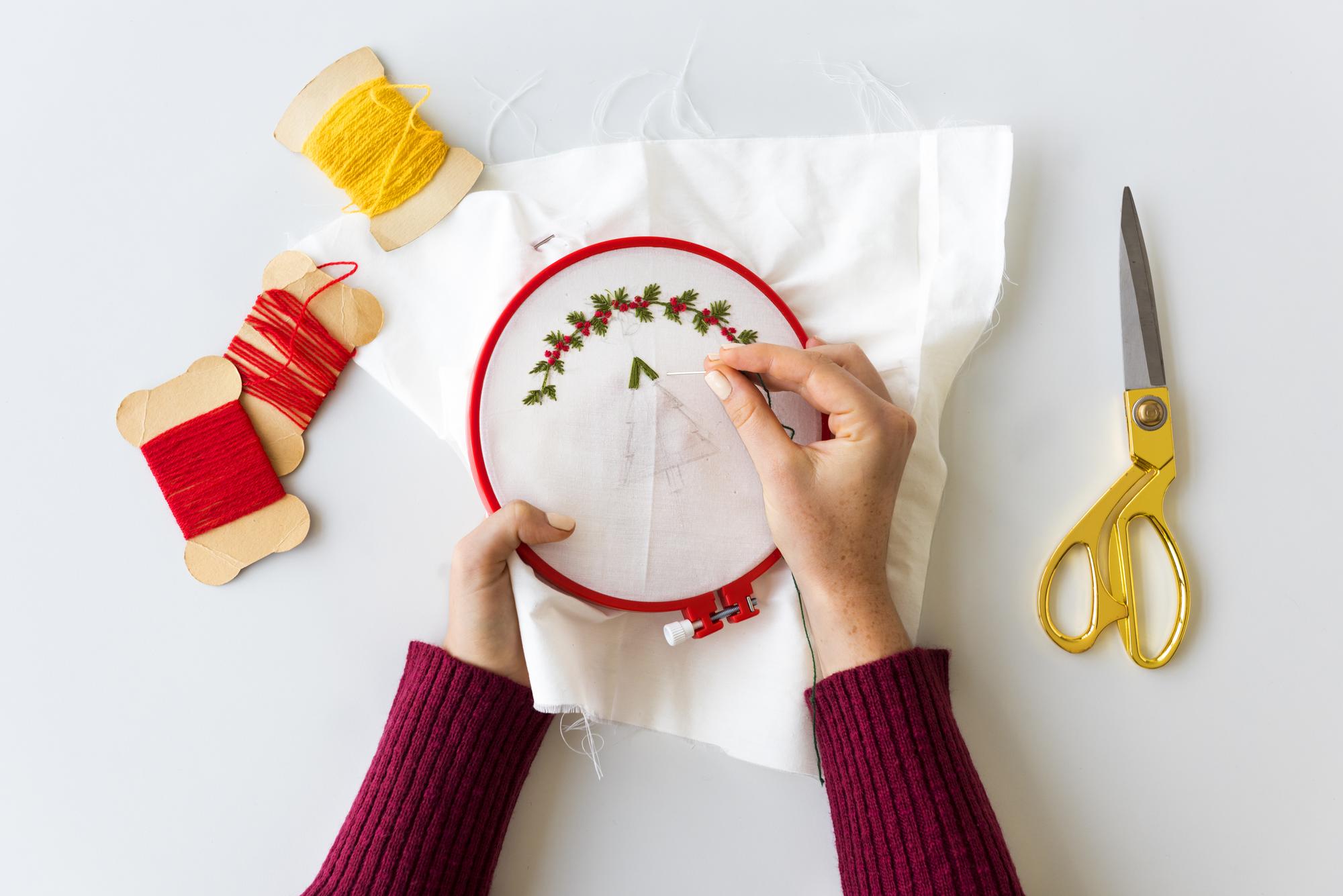 Hands arranging embroidered patches on table
